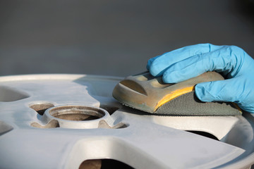 uomo carrozziere a lavoro su ruota auto