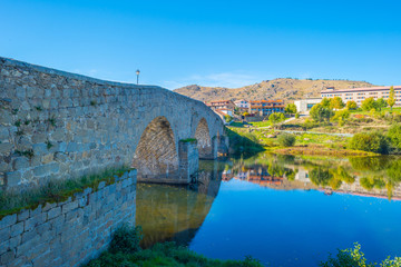 Fototapeta na wymiar Medieval bridge over a river in sunlight