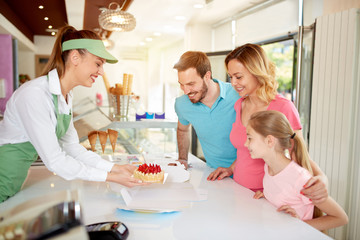 Obraz na płótnie Canvas Saleswoman packing fruit cake for family