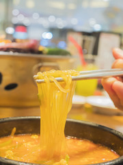 Selective focus of chopstick with noodle ready to be eaten