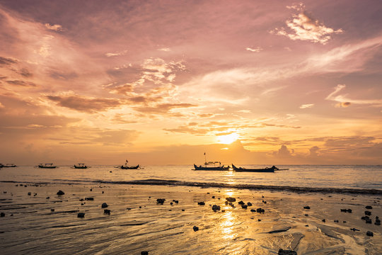Boats on warm sunset on ocean coast. Picturesque seascape on Bali island