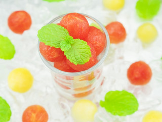 Small sphere shape of cantaloupe and watermelon in a glass with mint and ice decoration