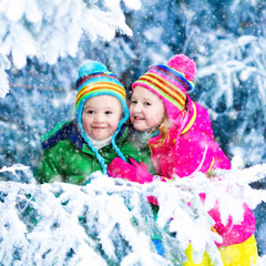 Fototapeta na wymiar Kids playing in snowy forest