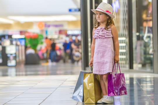 cute little girl in fashionable hat on shopping. portrait of a k