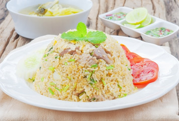 Fried rice with chili sauce and soup on wooden table
