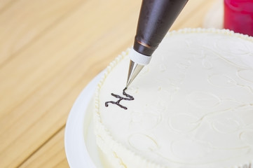 Cake decorating using piping tip for writing a word