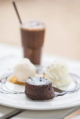 Chocolate cake with chocolate sauce and ice cream on white plate