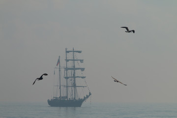 Tall ship sailing in the sea in foggy misty day.