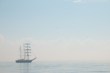 Tall ship sailing in the sea in foggy misty day.