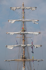 Vintage sailing ship mast ropes and tackle, Tall ship rigging mast detail, blue sky background