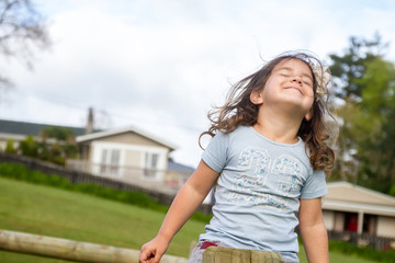happy child girl enjoying being outdoors on natural background
