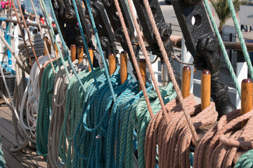 Naklejka premium Deck and ropes, rigging on a wooden tall ship sail yacht. Close up view