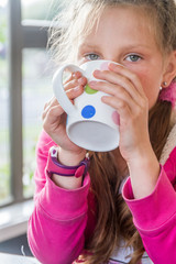 portrait of young happy child girl drinking