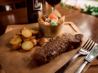 Juicy beef steak with potatoes and wine