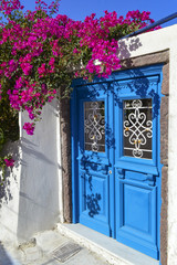 Obraz na płótnie Canvas Doors and flowers in the typical and tourist island of Santorini in Greece