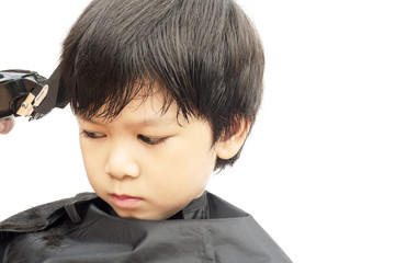 A boy is cut his hair by hair dresser isolated over white background