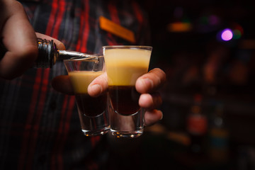 Fototapeta na wymiar bartender pours a cocktail b 52 close-up