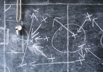 whistle of a soccer or football referee on black board with tactical diagram