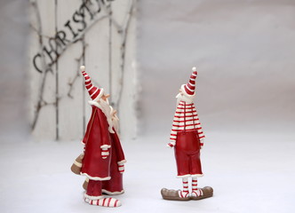 2 and a half santa claus, two large and one small funny figures of santa claus in front of descreet...