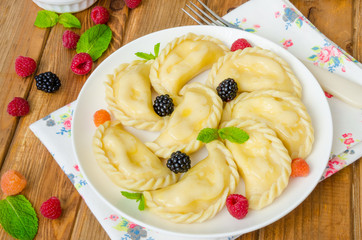 Homemade dumplings (vareniki) with cottage cheese and berries. Traditional Ukrainian and Russian dish.