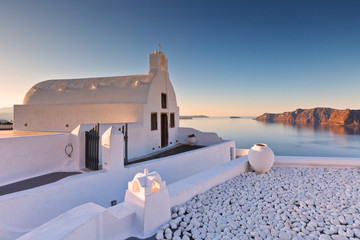 Small white church in Oia village on Santorini island, Greece.