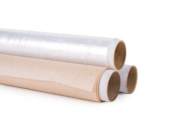 One roll of plastic wrap, one roll of aluminum foil and One roll of parchment paper for household use on a light background. Isolation.