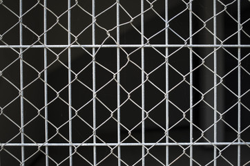 Gray net on grate on black background