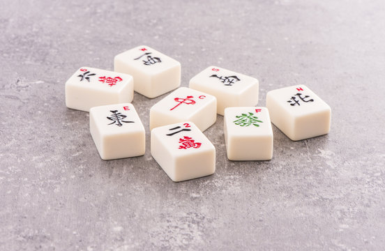 Mahjong board game pieces lying on stone table. Concept of asian or chinese leisure activity, recreation and traditional games.