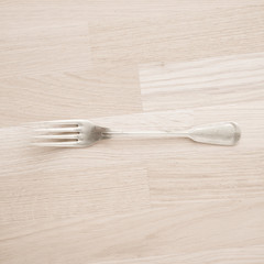 Silver fork lying on wooden table with copy space. Still life of vintage cutlery in kitchen. Concept of eating, cooking or restaurant.