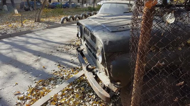 Rusty old abandoned car. Retro old Soviet Russian jeep UAZ. Steadicam shot.