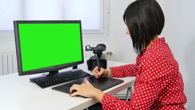 pretty young woman video editor with computer and professionnal video camera