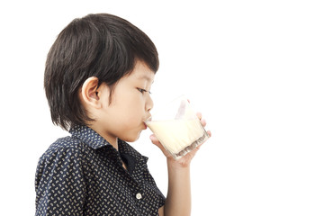 Asian boy is drinking a glass of milk  isolated over white background