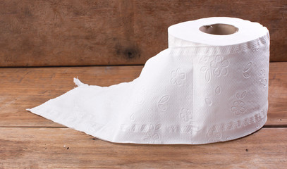 Toilet paper roll, which rests on a wooden desk.