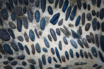 cobblestones in concrete background, Round stones in the ground.
