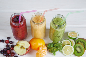 Smoothies of kiwi, mandarin, banana, Lemon, apple, currants, berries and broccoli on a white background