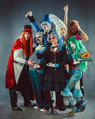 The troupe of mad circus actors on the grey background.