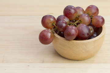 group of fresh red grape in bowl on wood table