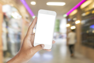 Hand holding smartphone with blurred image of shopping mall