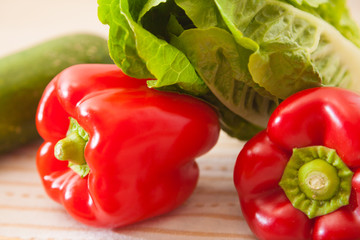 red paprika lies with other vegetables on a table