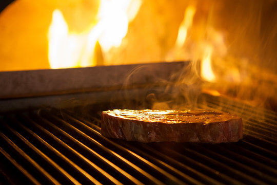 cooking the meat on the grill in the fireplace in the restaurant