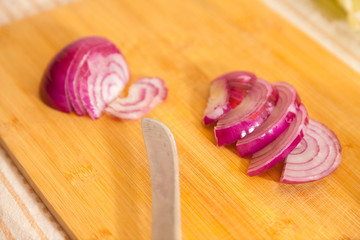 cropped onion with other vegetables on a cutting board