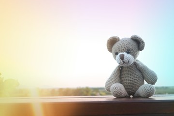 Cute crochet teddy bear doll under sunlight