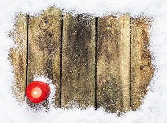 Rote Adventskerze auf verschneiten Holzbrettern, Draufsicht