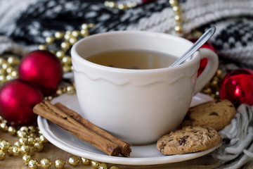 Green tea with chocolate cookies and cinnamon sticks, christmas decoration sa background. Christmas morning and breakfast concept. Christmas celebration