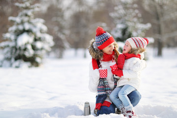 happy family mother and child on winter walk drinking tea