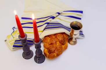 table set for Shabbat with lighted candles, challah bread and wine.
