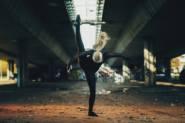 Attractive jazz ballerina dancing under the overpass