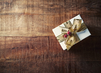 Christmas Present with Gold Ribbon on Rustic Wooden Background