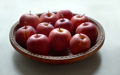 Apples on the wooden and hand-made platter