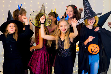 Happy group of teenagers dance in Halloween costumes